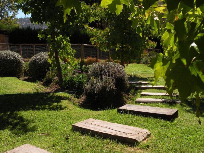 Durmiente de madera nativa instalado en jardín como elemento decorativo y funcional
